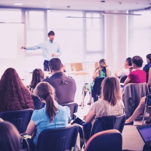 Image of a teacher in front of a room of adult learners