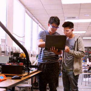 two students looking at a laptop