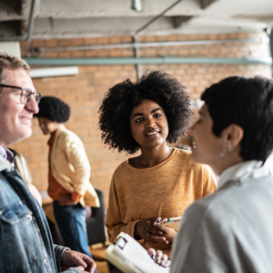 Photo of group of 3 people talking. 