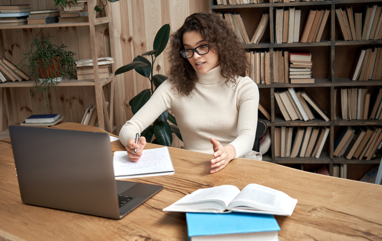 a professional writing a curriculum vitae and cover letter on a laptop